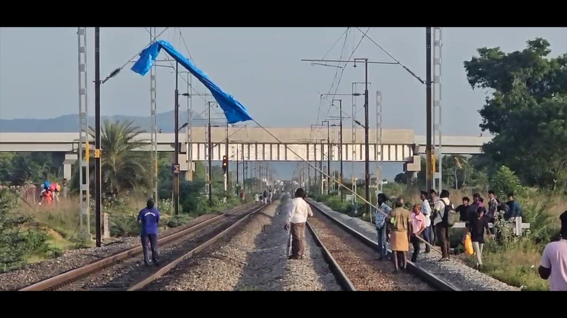திருவள்ளூர் மாவட்டம் திருத்தணி அருகே மின்சாரக் கம்பி மீது தொங்கிய தார்ப்பாயால் ரயில்கள் தாமதம்