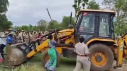 குடிசைகளை அகற்ற வந்த அதிகாரிகள் மீது மிளகாய் பொடியை வீசியும், கட்டைகளால் அடித்தும் தாக்குதலில் ஈடுபட்ட பழங்குடியின மக்கள்